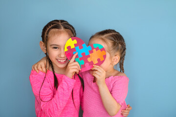 Shy Children hide their faces behind a large heart with multicolored grooves inside. A card...