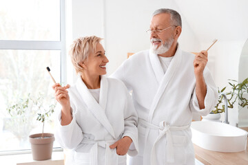 Mature couple brushing teeth in bathroom