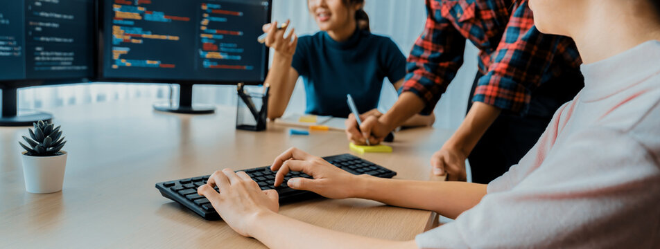 Young Professional website developer and cooperative computer engineer team brainstorming and sharing idea of program writing and coding at modern meeting room. Teamwork concept. Closeup. Burgeoning.