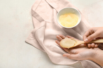 Female hands with natural body scrub on light background, closeup