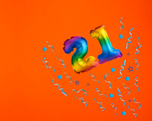 Multicolor balloon number 21 - Confetti explosion on orange background. Birthday card