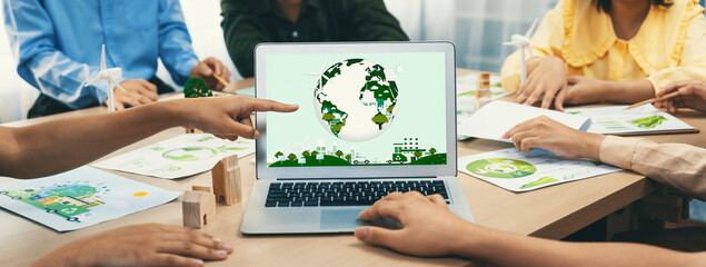 Green city logo displayed on a laptop at a green business meeting. Team presenting green design to...