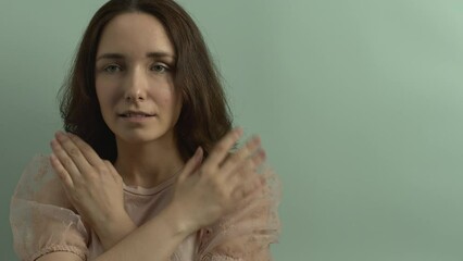 Female touching and tapping her shoulders, crossing hands. Butterfly hug. Psychology and self-care concept. Empty background with copy space.