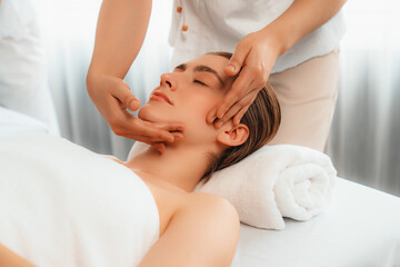 Obraz na płótnie Canvas Caucasian woman enjoying relaxing anti-stress head massage and pampering facial beauty skin recreation leisure in dayspa modern light ambient at luxury resort or hotel spa salon. Quiescent