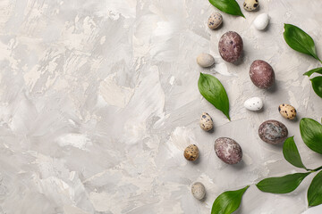 Easter eggs with leaves on grunge grey background