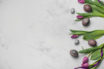 Easter eggs with tulip flowers and ribbon on white grunge background