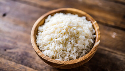 Cooked rice in bowl on wooden background, symbolizing nutrition, sustenance, Asian cuisine. Copy space for food-related concepts