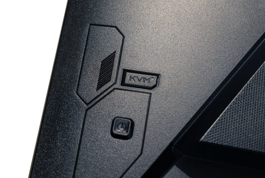 Close-up view of the rear section of a Gigabyte M27Q computer monitor with an in-built KVM switch and on on off button joystick for settings access, detail up close