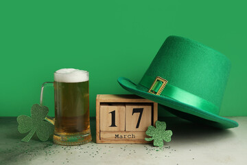 Cube calendar with date 17 MARCH and glass of beer on grunge table. St. Patrick's Day celebration