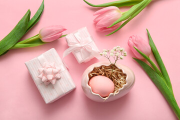 Easter egg with flowers and gift boxes on pink background