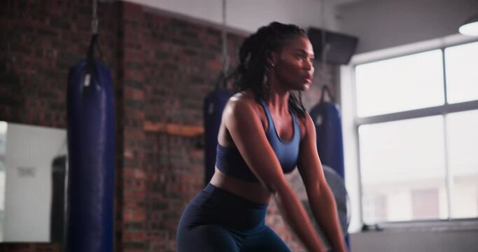 Black woman, kettlebell and weightlifting at gym for workout, strength or body exercise. Active African female person, athlete or bodybuilder in sports, muscle gain or training in health and wellness