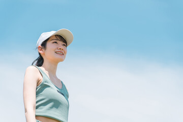 青空の下で運動・トレーニング・ウォーキングする女性
