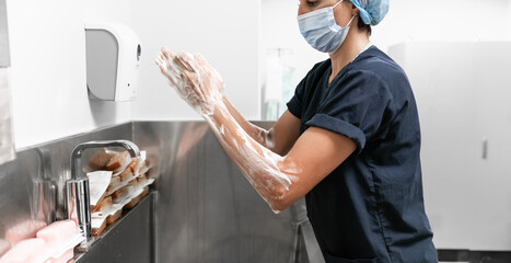 Surgeon having her hands surgically washed. A Caucasian doctor dressed in his right-hand profile...