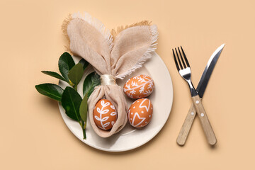 Stylish table setting with Easter eggs, napkin and cutlery on beige background