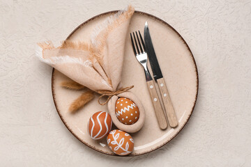 Beautiful table setting with Easter eggs, napkin and cutlery on grey background