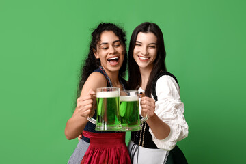 Irish waitresses with glasses of beer on green background. St. Patrick's Day celebration