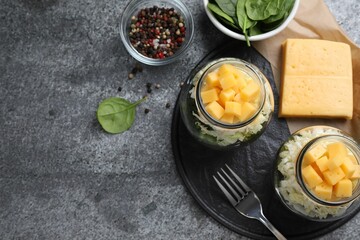 Healthy salad in glass jars on grey table, flat lay
