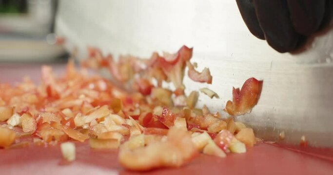 Chef chop red bell pepper with an axe. Male hands cut vegetables, close-up