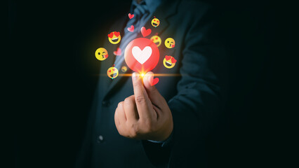 A businessman uses a mobile phone to send a heart emoji to his girlfriend on Valentine's Day. Valentine's Day concept,  love care, Man wearing a suit holds a mobile phone forwarded heart emoji.