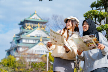 Travel, muslim travel, woman girl tourist Two Asian friends but different religions walking and...