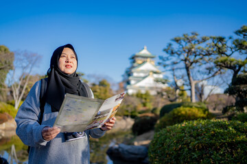 Travel, Muslim travel, Asian Muslim female tourist walking and visitor learning about history at...