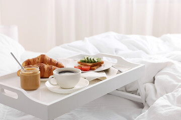 Good morning. Tray with tasty breakfast on bed at home