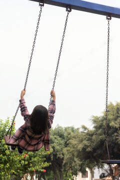 Ni&ntilde;a jugando en un columpio en un parque durante  el d&iacute;a