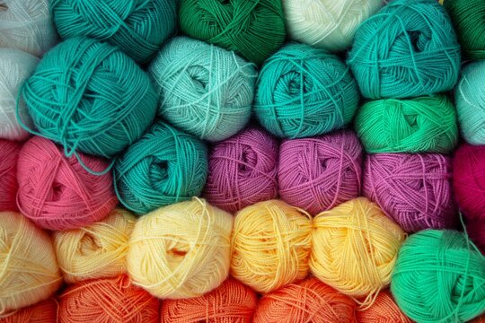 Ovillos de lana de muchos colores pastel expuestos en tienda
