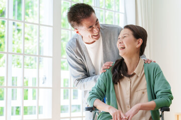 車椅子に乗った妻を支える夫