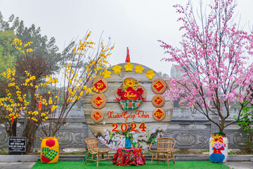 Blooming yellow flower and red flower decoration at Tranh temple for Lunar new year with text "Spring 2024 " "year of the Dragon 2024" in Vietnam.