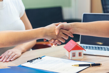 Close up Businesswoman shakes hands customer dealing real estate house agent signing contract....