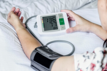 Closeup view of a person performing blood pressure measurement at home.