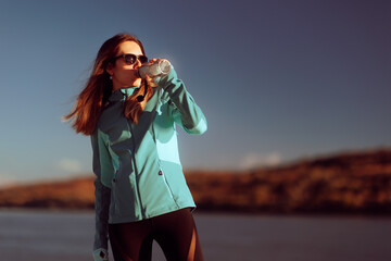 Sportive Woman Drinking Water Outdoors After Running. Cool sportswoman hydrating with an energizing...