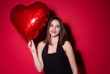 Valentines day, love heart. Portrait of lovely valentine girl hold red heart on red studio background. Beautiful woman celebrate valentine. Woman in love. Woman on Valentines Day.