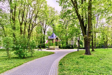 Beautiful spring park with a path and a gazebo