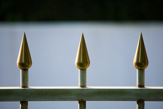 Stainless steel fence, golden arrow, anti-theft spike, arranged in a line,Iron fence with spider web in the park. 