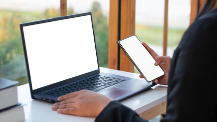 Tablet and smartphone with blank screen on desk. businessman using modern smartphone in his home...