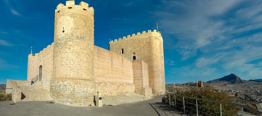 Medieval Jumilla castle with large keep circular tower on a hilltop in Spain with blue sky © tamas