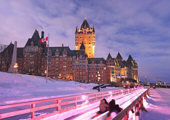 Traditional slide descent in winter in Quebec City with Frontenac Castle illuminated at dusk