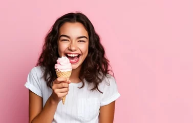 Schilderijen op glas Summer portrait of happy young woman eating ice cream wearing sunglasses on pink background. © Наталья некрасова