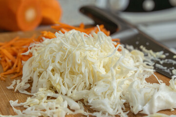 Thinly sliced white cabbage for making salad. Homemade food. Veganism and raw food diet concept.