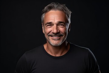 Obraz premium Portrait of a happy mature man on a black background. Portrait of a smiling mature man.
