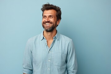 Portrait of a happy young man smiling at camera against blue background