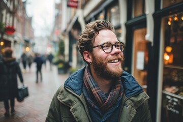 Portrait of a handsome young man with beard and glasses in the city - obrazy, fototapety, plakaty