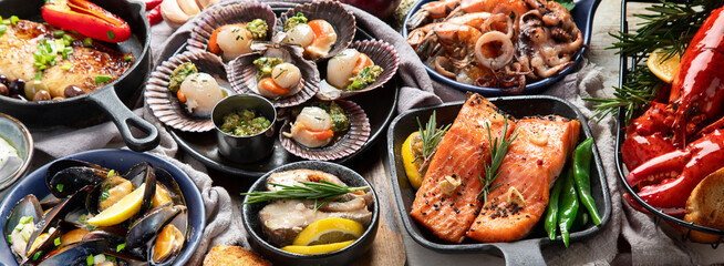 Set of Seafood dishes on light wooden background.