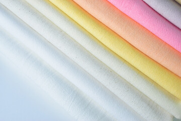 stack of colourful cotton clothes, pile of clothing on white background