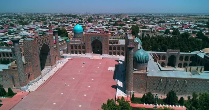 A drone flies over an ancient complex Bibi Khanym Mosque. Sunny summer day. Samarkand, Uzbekistan.