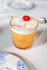 An amaretto sour cocktail topped with maraschino cherry at a French bistro-style restaurant in Circular Quay, Sydney — New South Wales, Australia