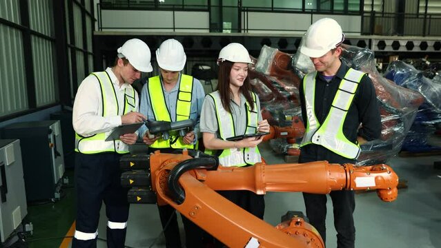 Teamwork engineers robots electricians men and women brainstormed successfully high five testing electrical and electronic systems checking services new welding robots working in the warehouse.