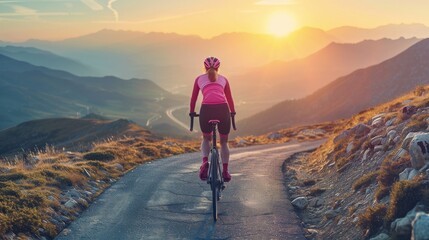 Woman riding bicycle at mountain during sunset